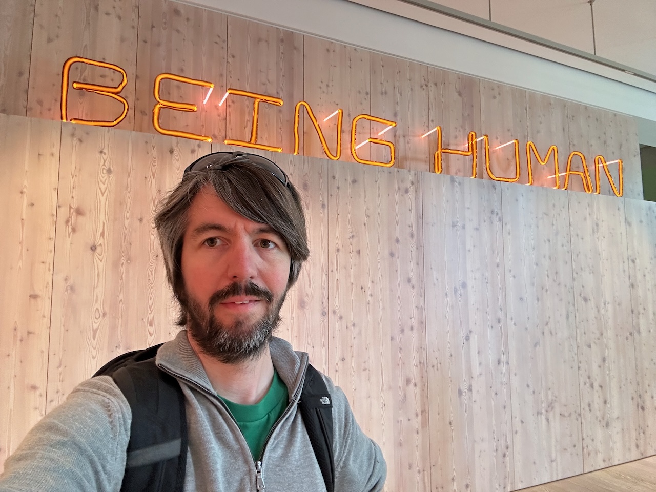 Photo of me standing in front of a sign saying 'Being Human'