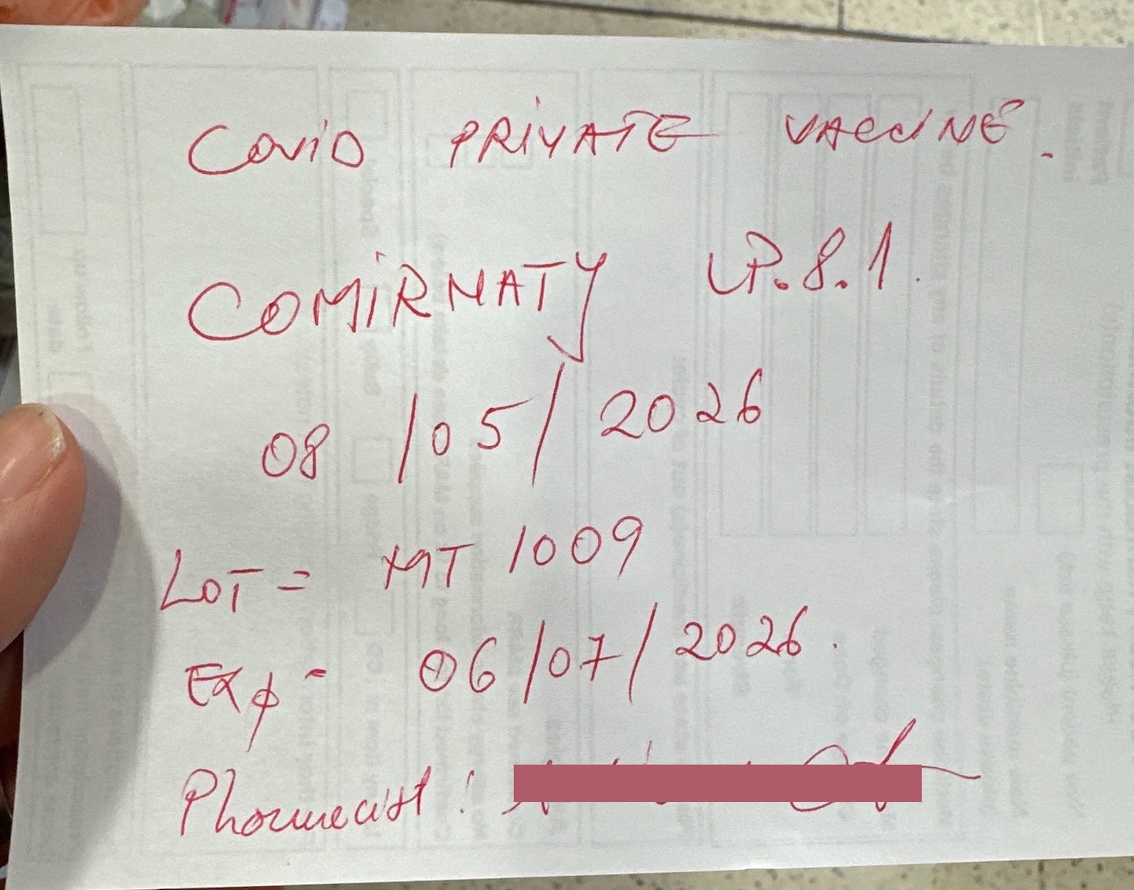 Photo of a piece of paper with notes hand written in red pen saying ‘COVID private vaccine. Comirnaty LP.8.1, 08/05/2026, LOT=MT1009, EXP=06/07/2026’ and a pharmacist’s name which has been censored.