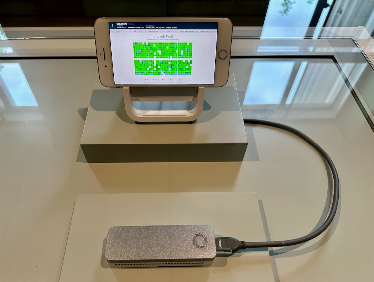 Photo a small medical device attached to a smartphone with small blue squares on its screen